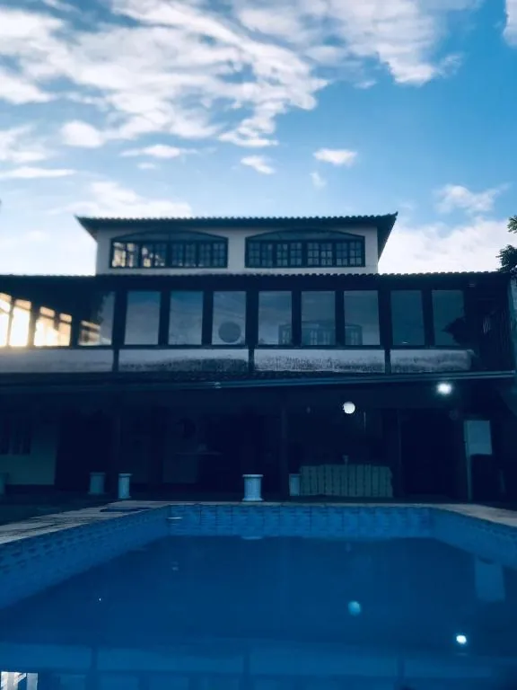 Piscina com a casa do hostel ao fundo