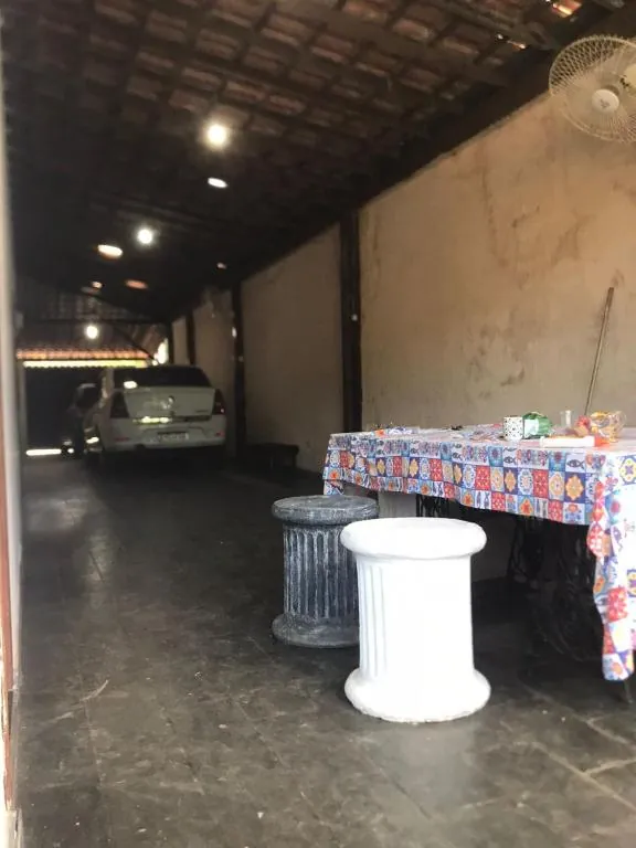 Área coberta com mesa, ao lado da garagem
